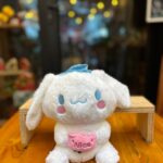 Amigo Mágico Bouquet: peluche blanco con moño azul y detalles rosas, adorable y tierno.