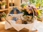 Canasta de regalo para bebé y mamá con flores, tazón dorado y ajuar de bebé
