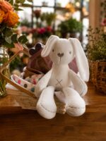 Peluche de conejo blanco dentro de la canasta de regalo para bebé