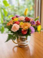 Taza con flores pastel y bombones de chocolate con forma de corazón