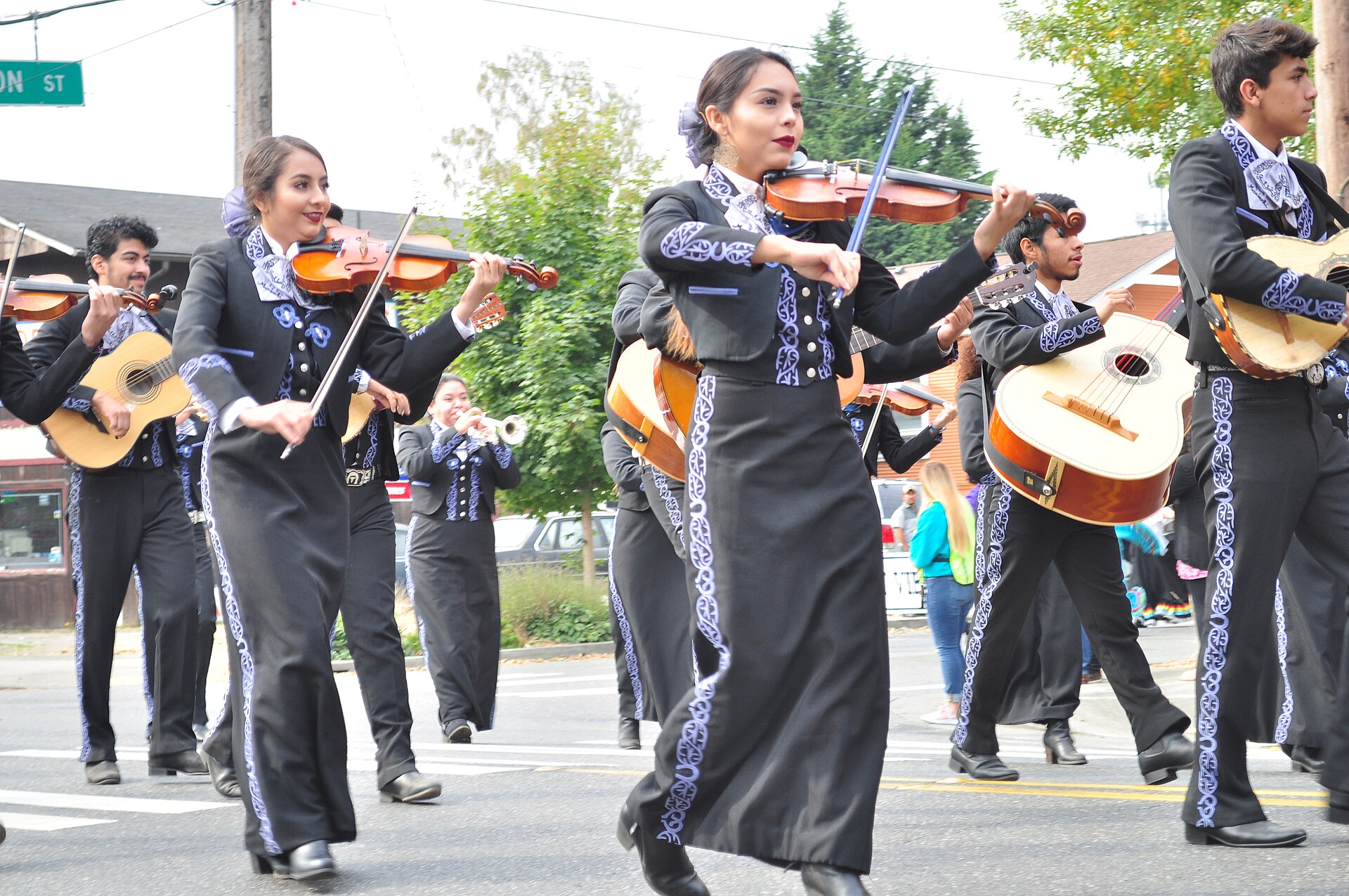 Grupo de cuatro mariachis con violines y guitarr&oacute;n en la calle